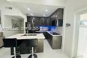 a kitchen with a sink refrigerator and cabinets