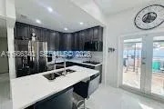 a kitchen with stainless steel appliances granite countertop a sink and a refrigerator
