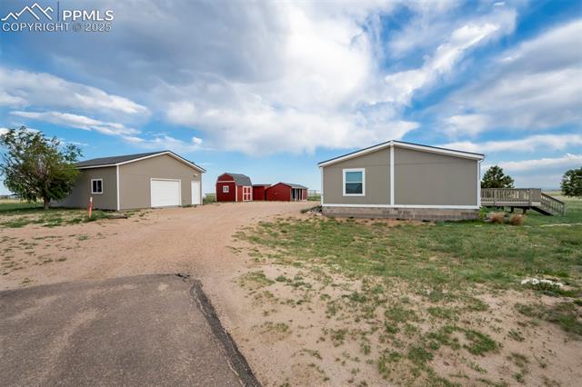 20150 Enoch Road Colorado Springs, CO 80928 - Photo 40 of 50 View of property exterior with an outbuilding, dirt driveway, and a deck