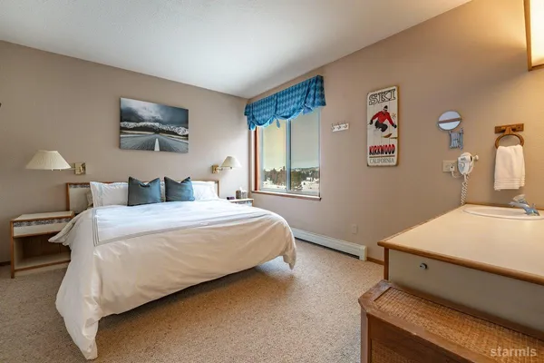 a spacious bedroom with a bed and a flat screen tv