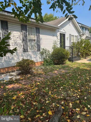 a white house that has a tree in front of it