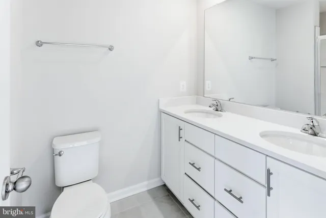 a bathroom with a granite countertop toilet sink and mirror