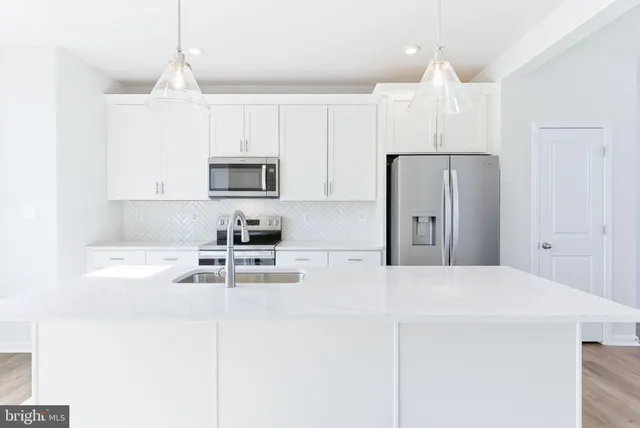a kitchen with stainless steel appliances white cabinets and a refrigerator