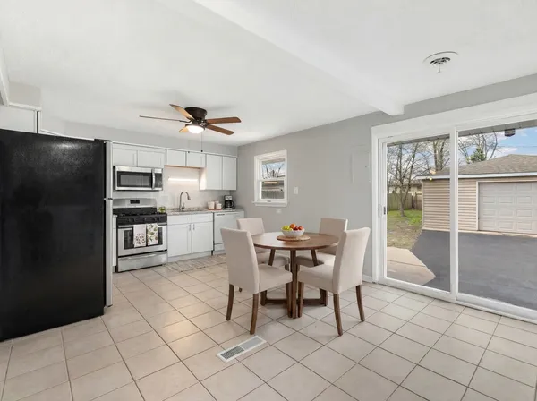 a kitchen with stainless steel appliances kitchen island granite countertop a refrigerator and cabinets