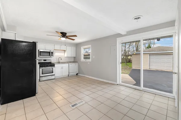 a view of kitchen with microwave and cabinets