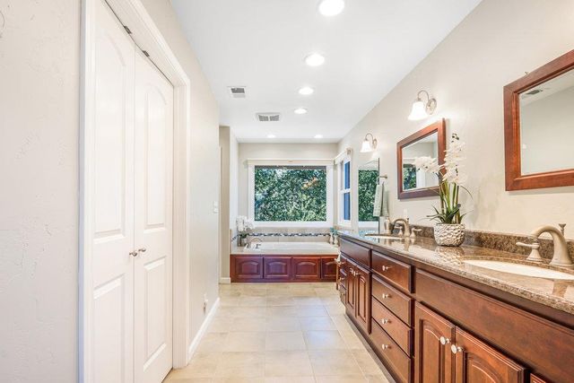 a bathroom with a granite countertop sink mirror and a bathtub