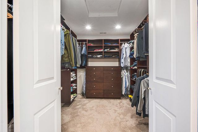 a view of walk in closet with clothes