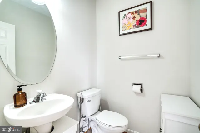 a bathroom with a toilet a sink and mirror