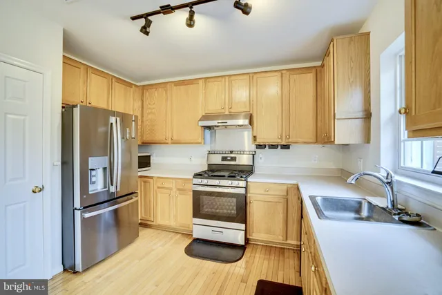 a kitchen with a stove a refrigerator and a sink