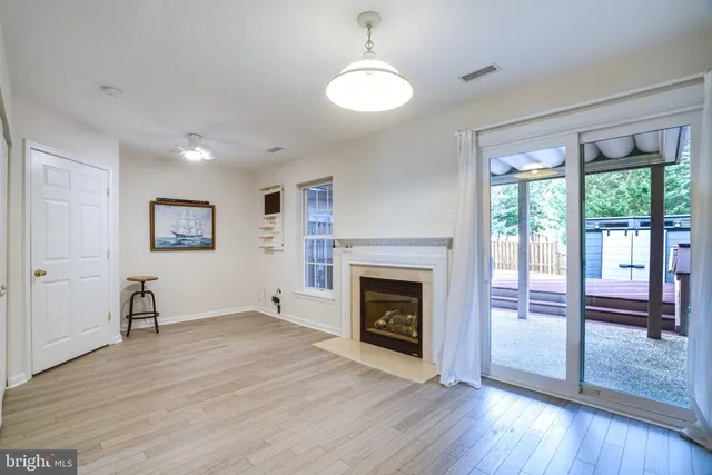 a view of empty room with wooden floor and fireplace