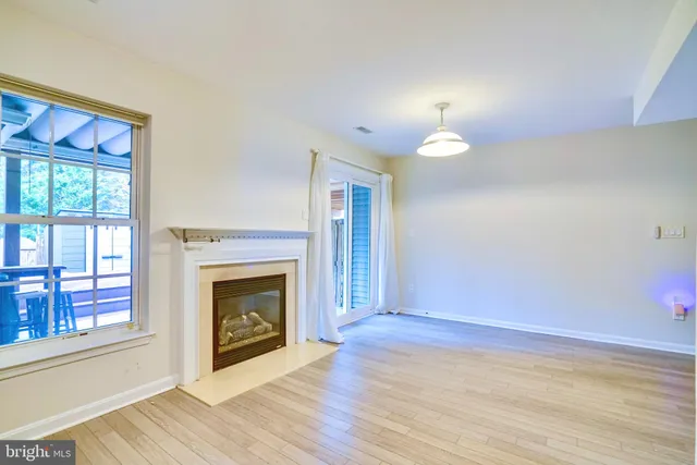 a view of an empty room with window and fire place