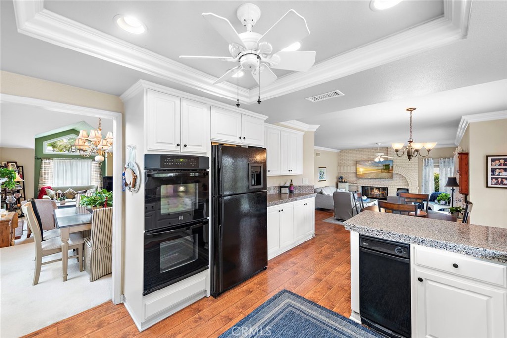 28811 Walnut Grove Mission Viejo, CA 92692 - Photo 11 of 48 a kitchen with kitchen island granite countertop a refrigerator a stove a sink dishwasher a dining table and chairs with wooden floor