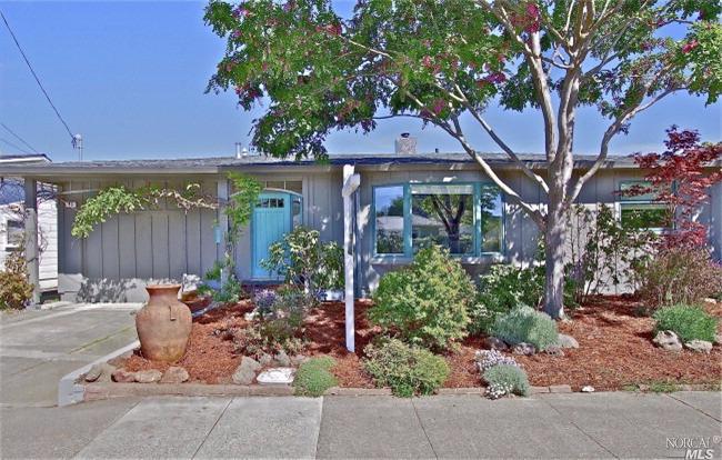 a view of a patio with table and chairs under an umbrella