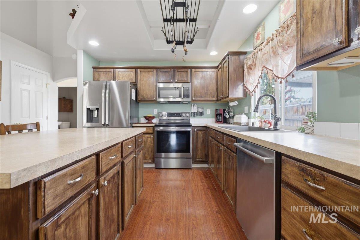 5002 Northrup Way Caldwell, ID 83607 - Photo 14 of 38 Kitchen with stainless steel appliances, light countertops, dark wood finished floors, recessed lighting, and arched walkways