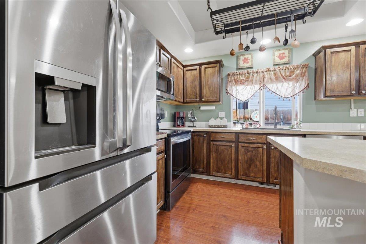 5002 Northrup Way Caldwell, ID 83607 - Photo 15 of 38 Kitchen featuring stainless steel appliances, light countertops, dark wood finished floors, and recessed lighting