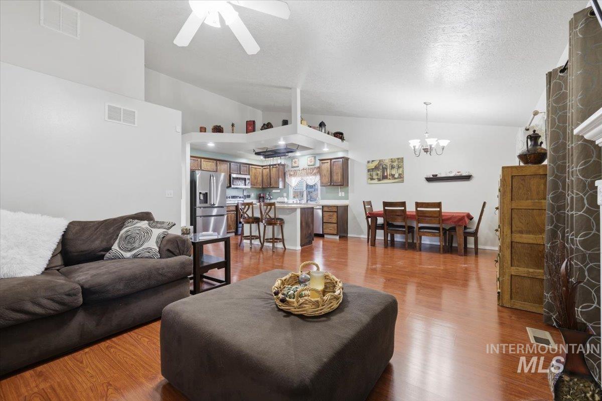 5002 Northrup Way Caldwell, ID 83607 - Photo 18 of 38 Living room with light wood-type flooring, ceiling fan, a high textured ceiling, and suspended lighting