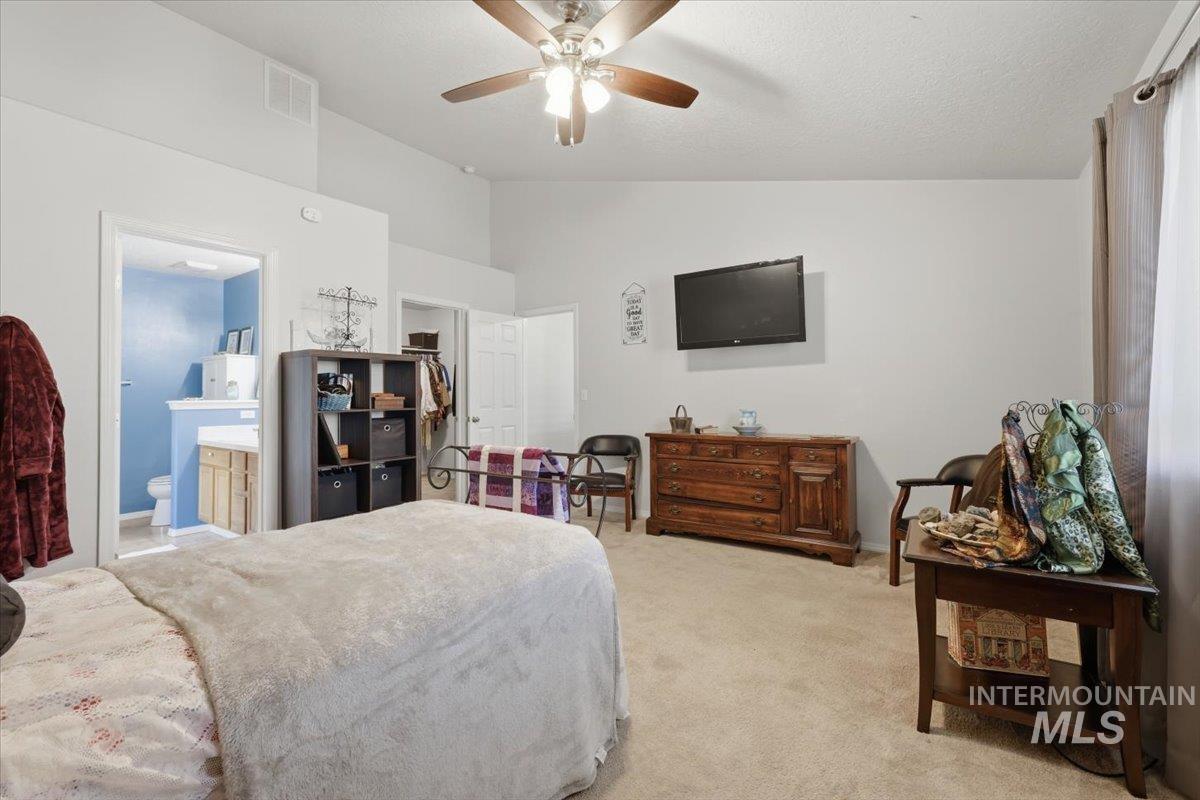 5002 Northrup Way Caldwell, ID 83607 - Photo 21 of 38 Bedroom with lofted ceiling, light colored carpet, ceiling fan, and connected bathroom