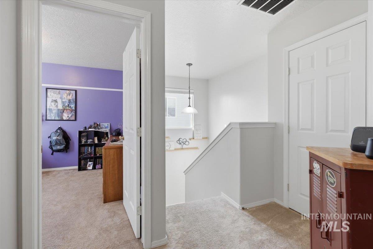 5002 Northrup Way Caldwell, ID 83607 - Photo 25 of 38 Corridor with light carpet, an upstairs landing, and a textured ceiling