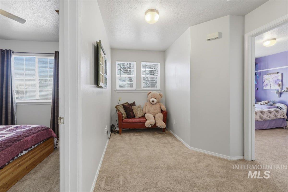 5002 Northrup Way Caldwell, ID 83607 - Photo 26 of 38 Bedroom with light carpet, a textured ceiling, and multiple windows