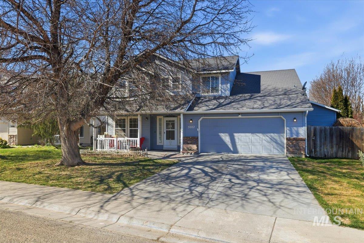 5002 Northrup Way Caldwell, ID 83607 - Photo 36 of 38 Traditional-style home with covered porch, a garage, concrete driveway, brick siding, and a shingled roof