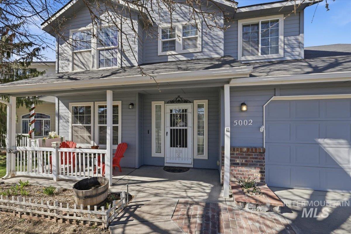 5002 Northrup Way Caldwell, ID 83607 - Photo 37 of 38 Entrance to property featuring a porch, a garage, and a shingled roof