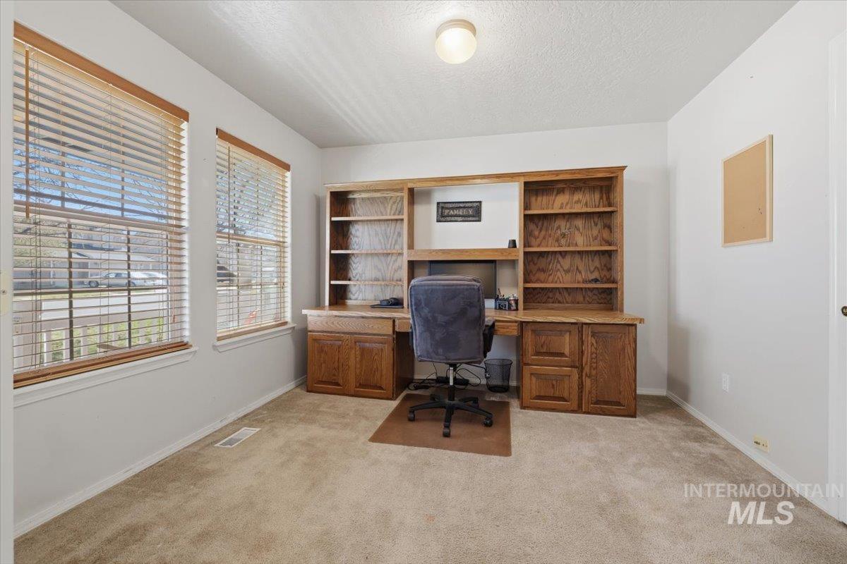 5002 Northrup Way Caldwell, ID 83607 - Photo 7 of 38 Home office with light colored carpet, a textured ceiling, and built in study area