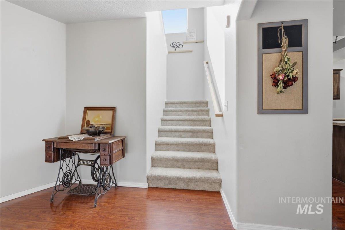 5002 Northrup Way Caldwell, ID 83607 - Photo 9 of 38 Stairs with wood finished floors and a textured ceiling