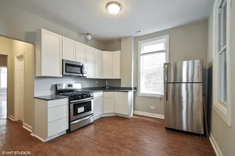 a kitchen with a refrigerator stove and wooden cabinets