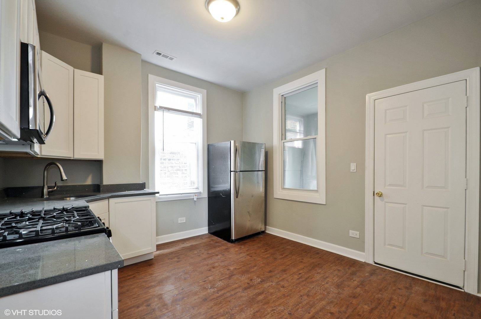 3833 West Arthington Street Chicago, IL 60624 - Photo 6 of 22 a kitchen with stainless steel appliances granite countertop a refrigerator and a stove top oven