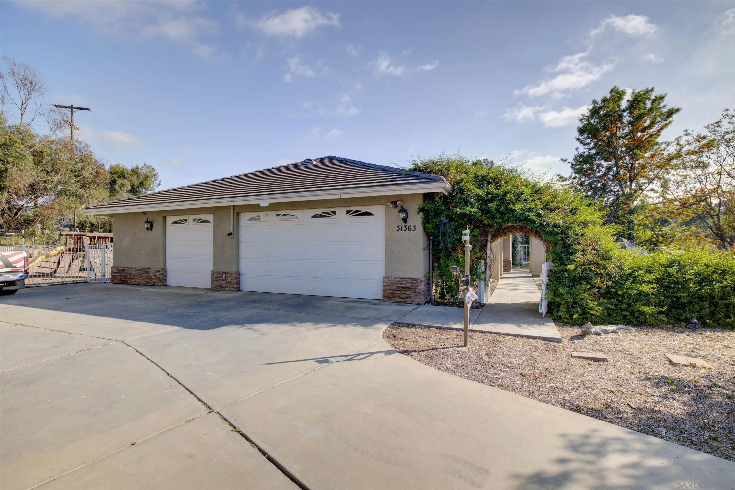 31363 Ahern Ranch Road Valley Center, CA 92082 - Photo 8 of 48 a front view of a house with a yard and garage