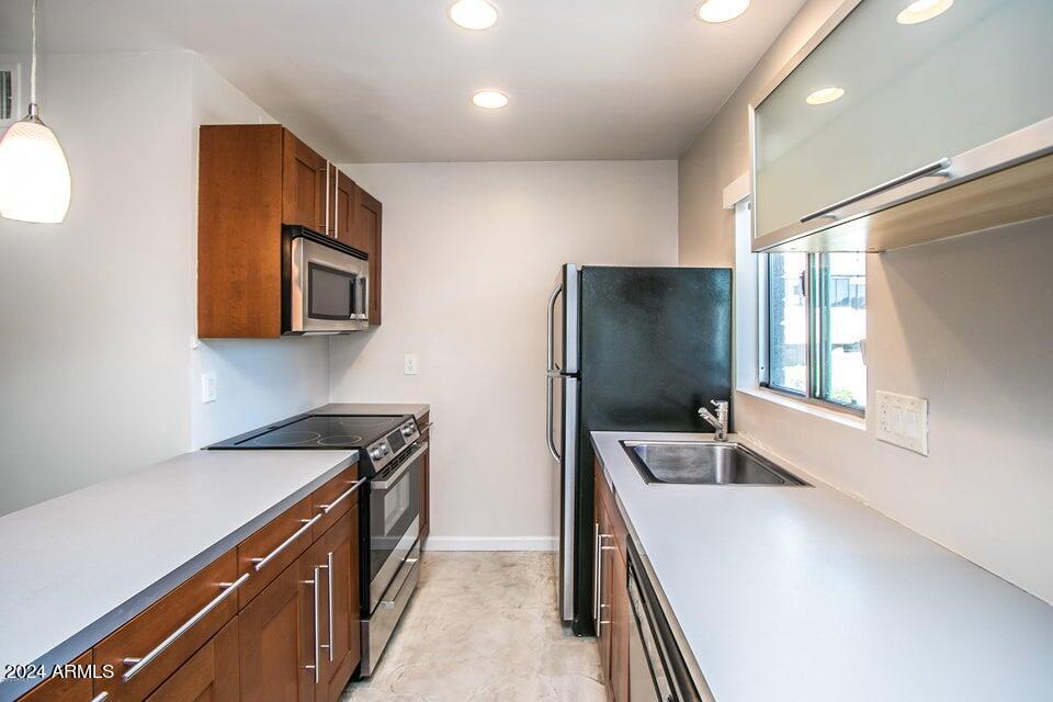 1630 East Georgia Avenue, Unit 208 Phoenix, AZ 85016 - Photo 7 of 23 a kitchen with stainless steel appliances a refrigerator a sink and wooden cabinets