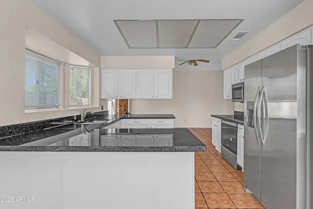 a spacious bathroom with a granite countertop sink a mirror and a bathtub