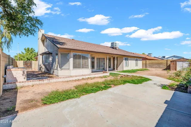 a backyard of a house with table and chairs