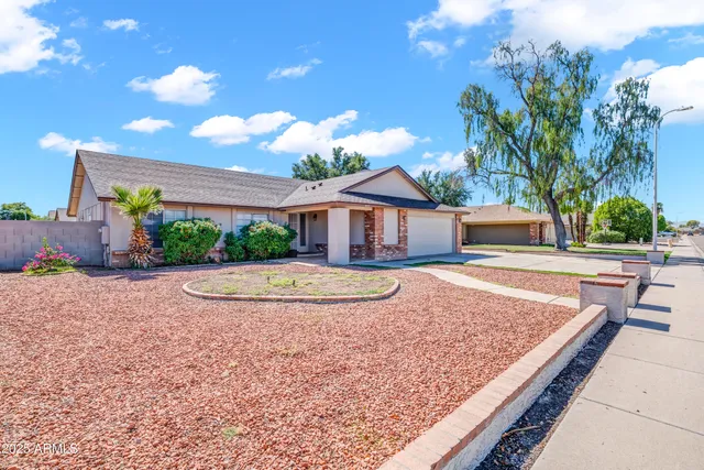 a view of house with backyard and trees