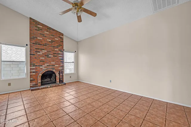 a view of empty room with fireplace and windows