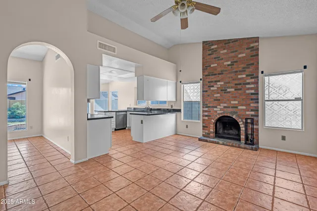 a kitchen with stainless steel appliances kitchen island granite countertop a refrigerator and a stove top oven