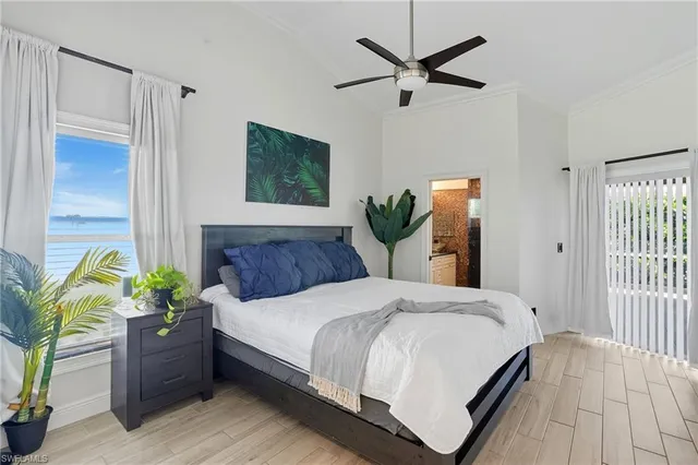 a bedroom with a bed potted plant with the wooden floor
