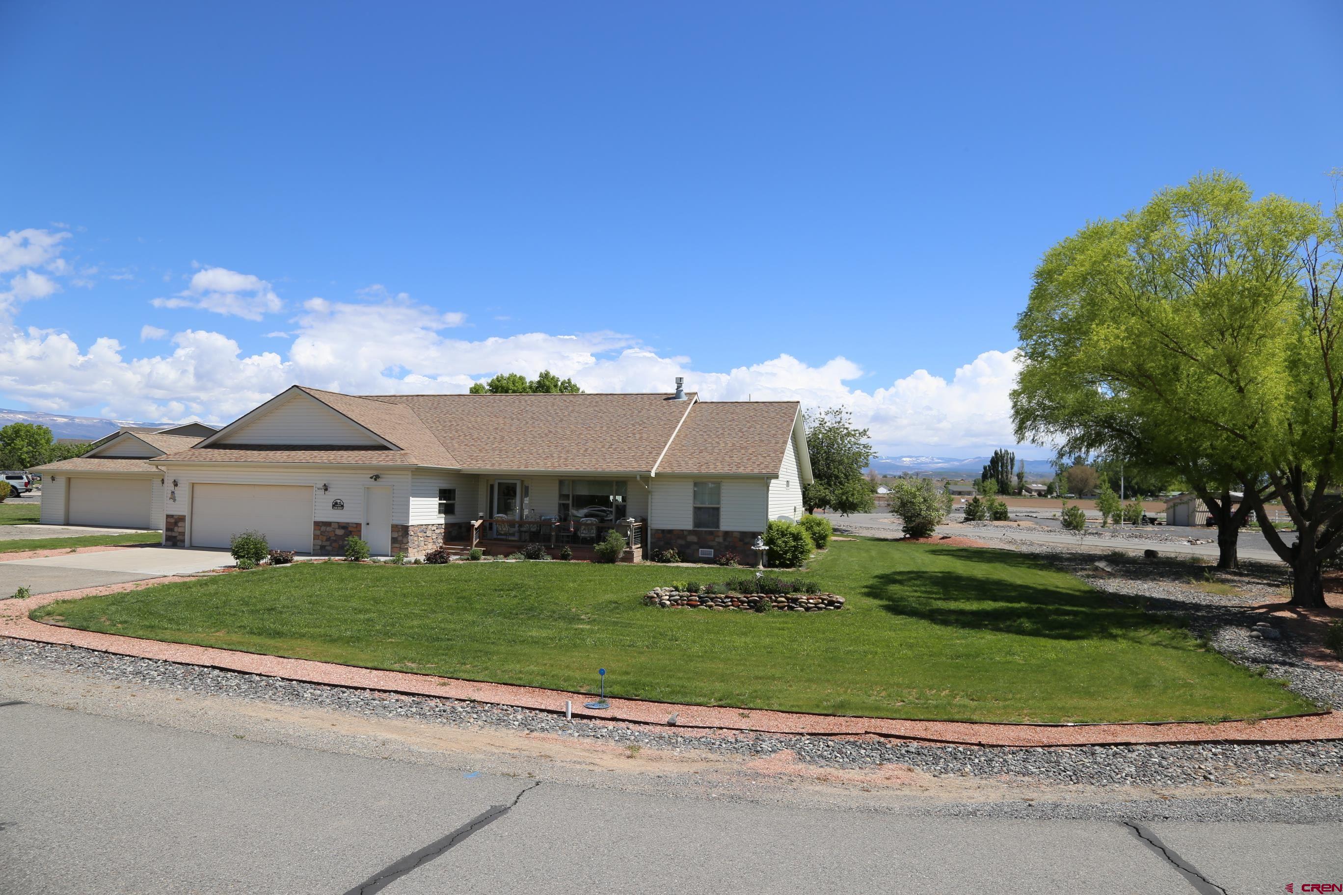 a front view of a house with a garden and trees
