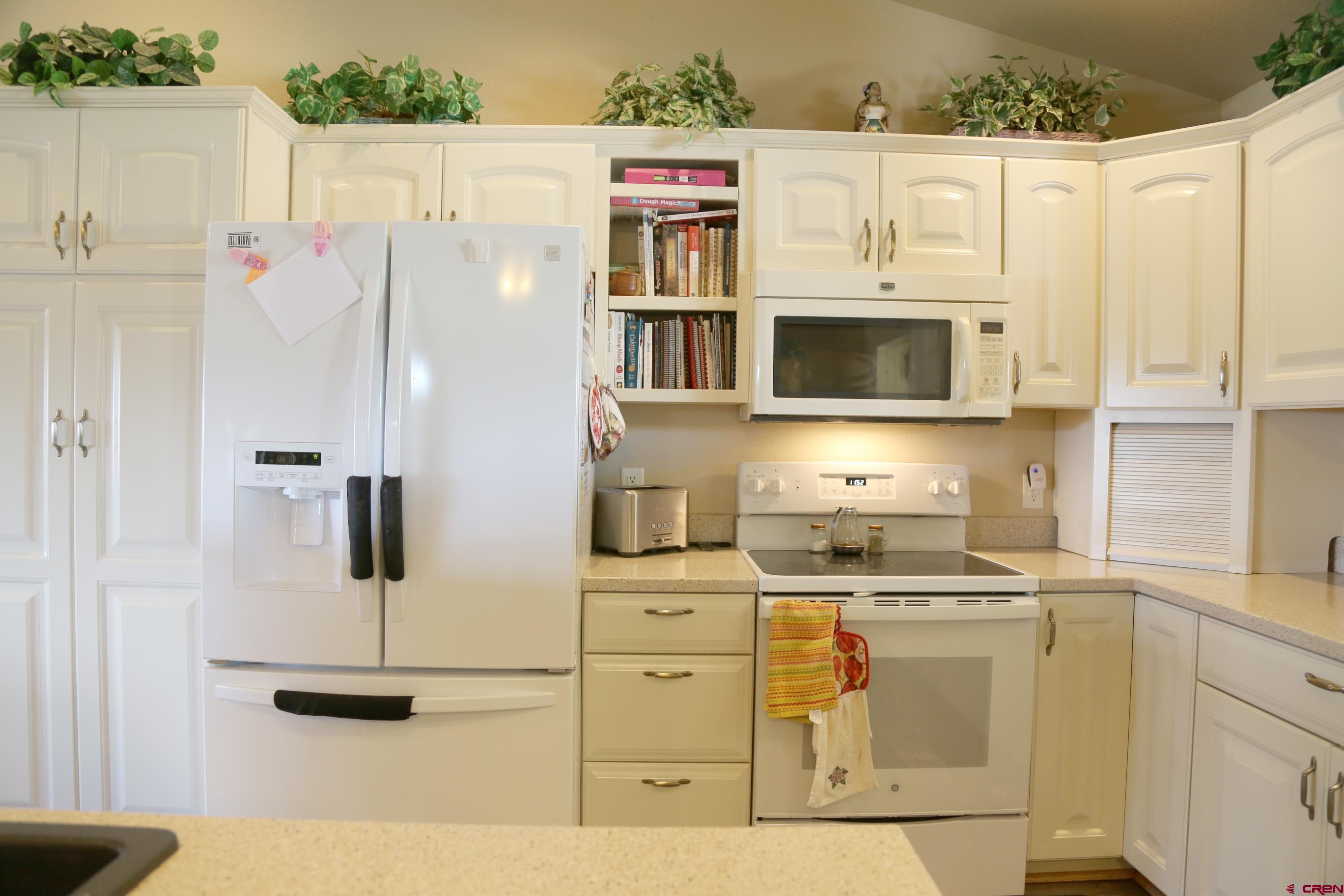 20287 Fox Ridge Drive Austin, CO 81410 - Photo 13 of 16 a kitchen with stainless steel appliances white cabinets and wooden floors