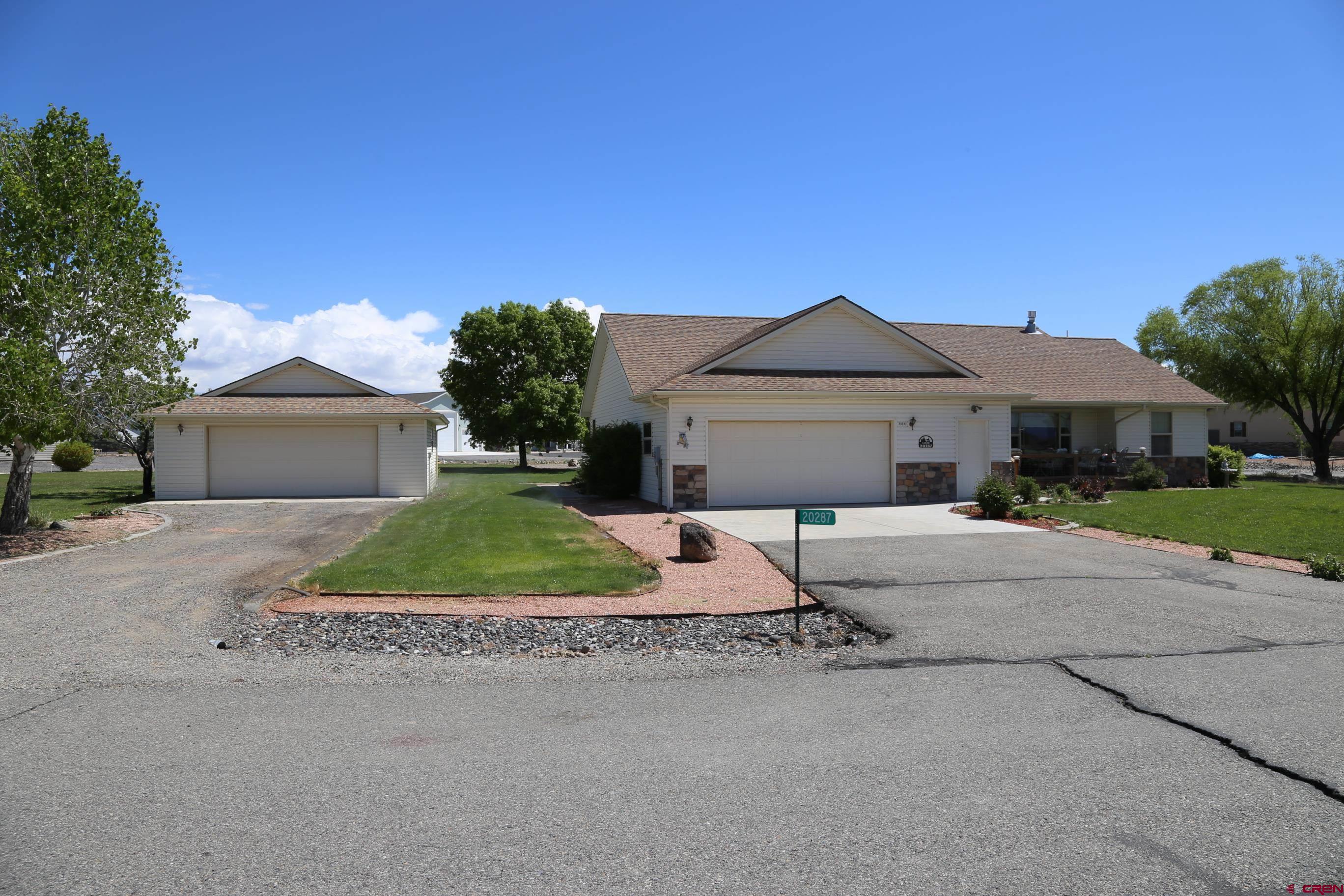 20287 Fox Ridge Drive Austin, CO 81410 - Photo 2 of 16 a front view of a house with a yard and garage