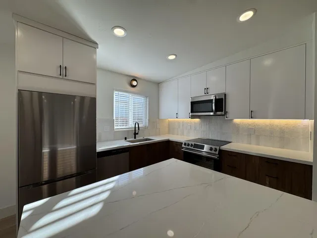 a kitchen with granite countertop cabinets and refrigerator
