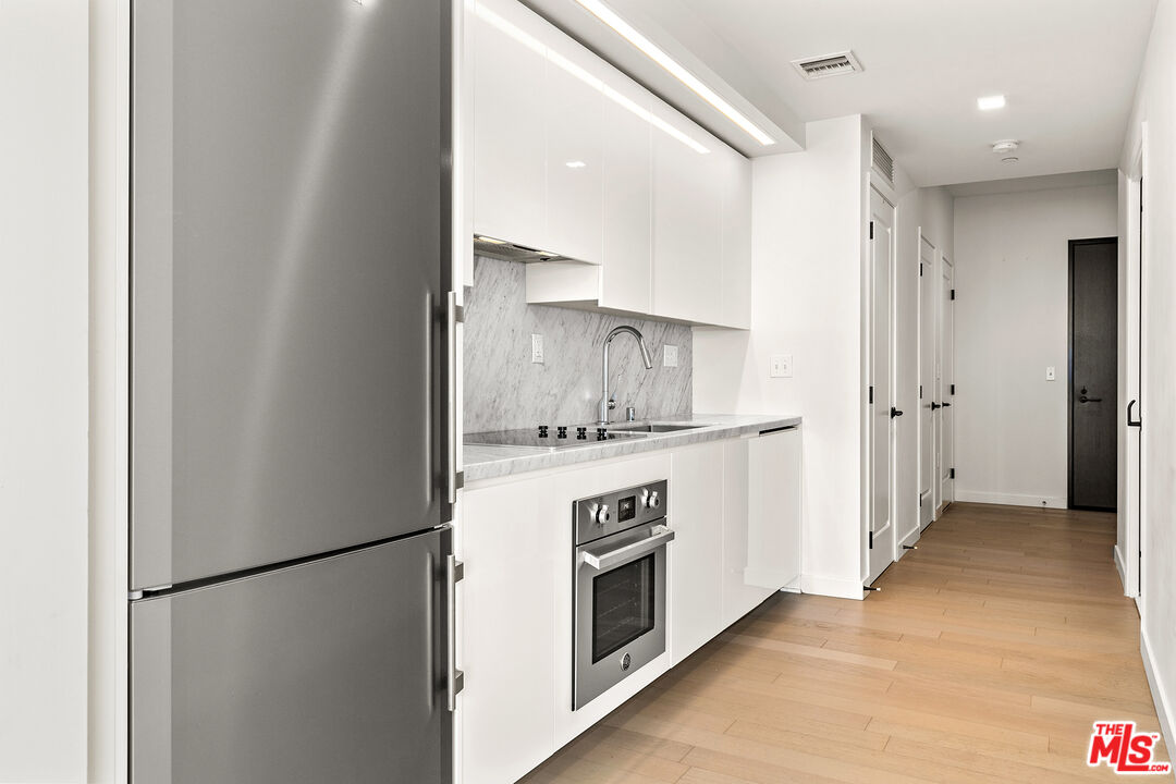 1050 South Grand Avenue, Unit 1405 Los Angeles, CA 90015 - Photo 1 of 11 a kitchen with a refrigerator sink stove and cabinets