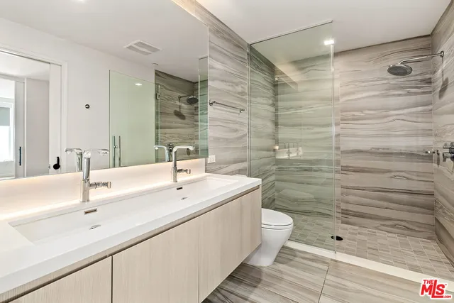 a bathroom with a double vanity sink toilet and shower