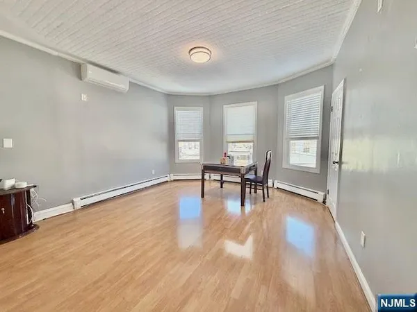 a view of empty room with wooden floor and floor to ceiling window