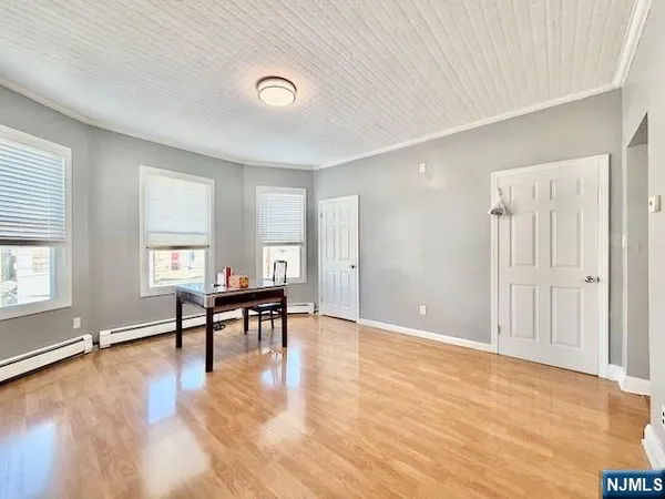 a view of empty room with wooden floor and furniture