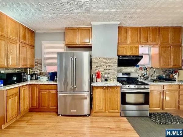 a kitchen with stainless steel appliances granite countertop a refrigerator and a stove top oven