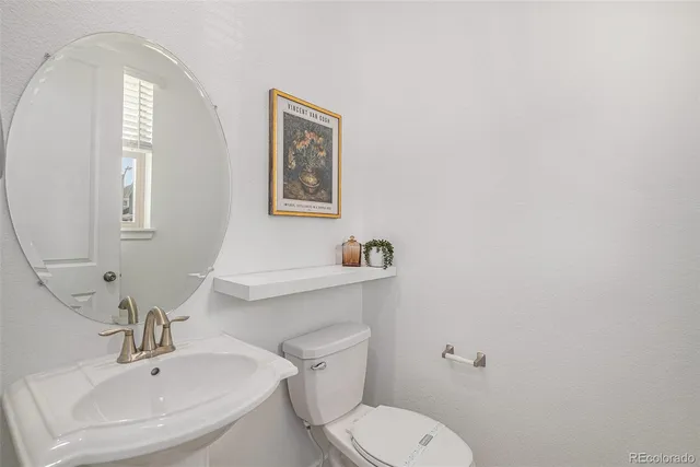 a bathroom with a toilet a sink and mirror