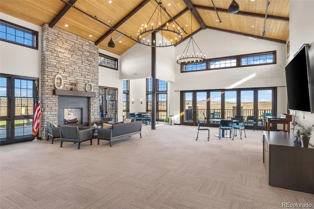 a living room with furniture a fireplace and large windows
