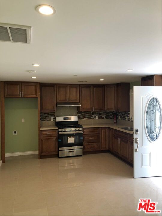 a kitchen with stainless steel appliances kitchen island granite countertop a refrigerator and stove