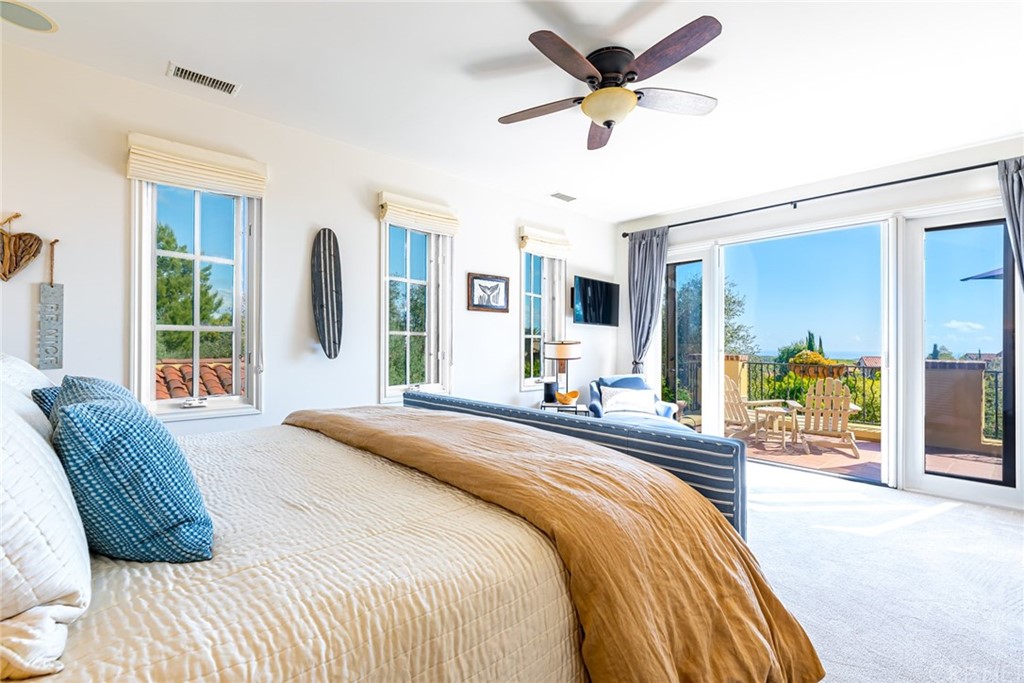 a bedroom with a bed a ceiling fan and a large window
